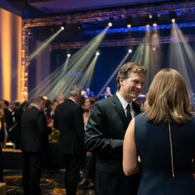 Gala ballroom with amber and blue LED uplighting and moving head light beams