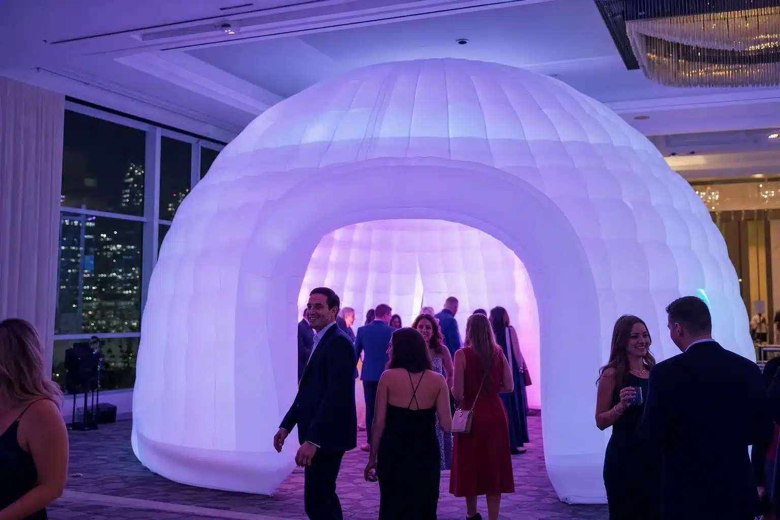 Guests walking into a 20 x 20 ft inflatable LED club glowing purple and blue at a Los Angeles event