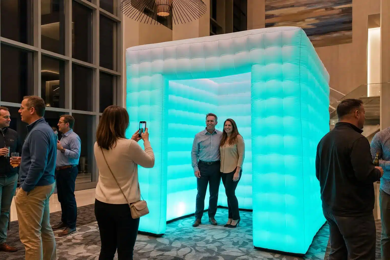 8 x 8 ft square inflatable LED booth glowing teal at a corporate event